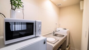 Une cuisine compacte équipée d’un four à micro-ondes, d’un évier et d’un petit plan de travail.