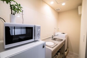 A compact kitchen with a microwave, sink, and a small countertop.