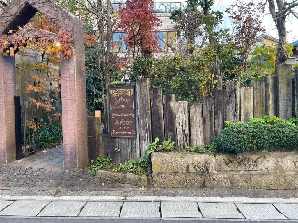 A wooden fence with a sign that reads 'Arbor House.'