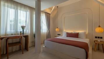 A modern bedroom with a large bed, bedside tables, a desk, and a window with curtains.