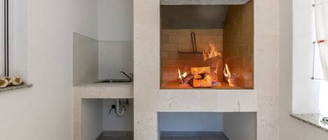 Eine moderne Küche mit eingebautem Kamin, einem Fenster und einer Spüle.