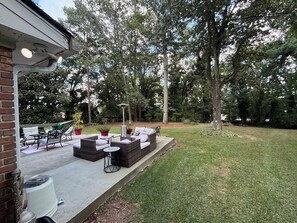 An outdoor patio area with a built-in seating arrangement, a fire pit, and a potted plant.