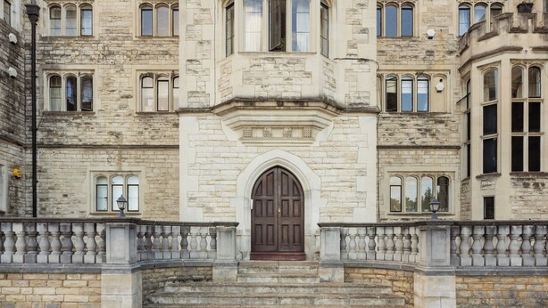 A historic building with a central entrance, multiple windows, and a symmetrical facade.