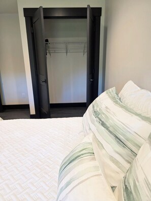 Una habitación de hotel con una cama, un armario y una puerta.
