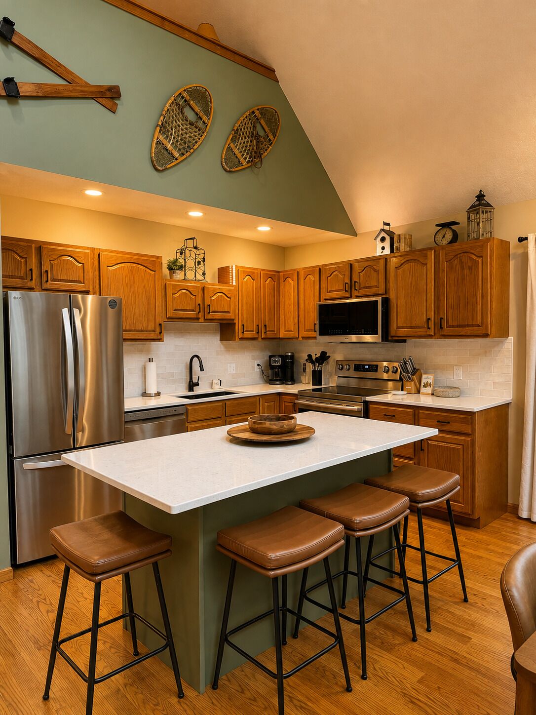 A modern kitchen with wooden cabinets, a stainless steel refrigerator, a microwave, and a large island with stools.