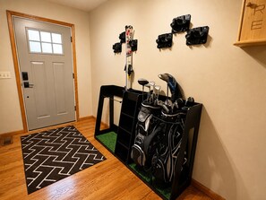 Una habitación con una puerta, un soporte para botes de golf y un bote de golf con palos.
