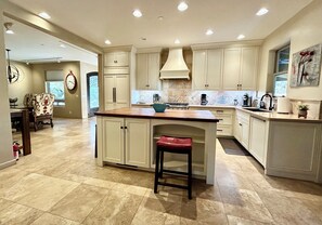 A spacious kitchen with a central island, ample counter space, and modern appliances. - Sedona Luxury 5-Bedrm Oasis, Pool-Spa, Yoga, Views (Sedona)