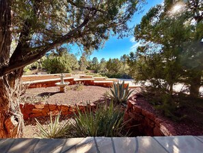 A landscaped garden with a stone fountain, surrounded by various plants and trees. - Sedona Luxury 5-Bedrm Oasis, Pool-Spa, Yoga, Views (Sedona)