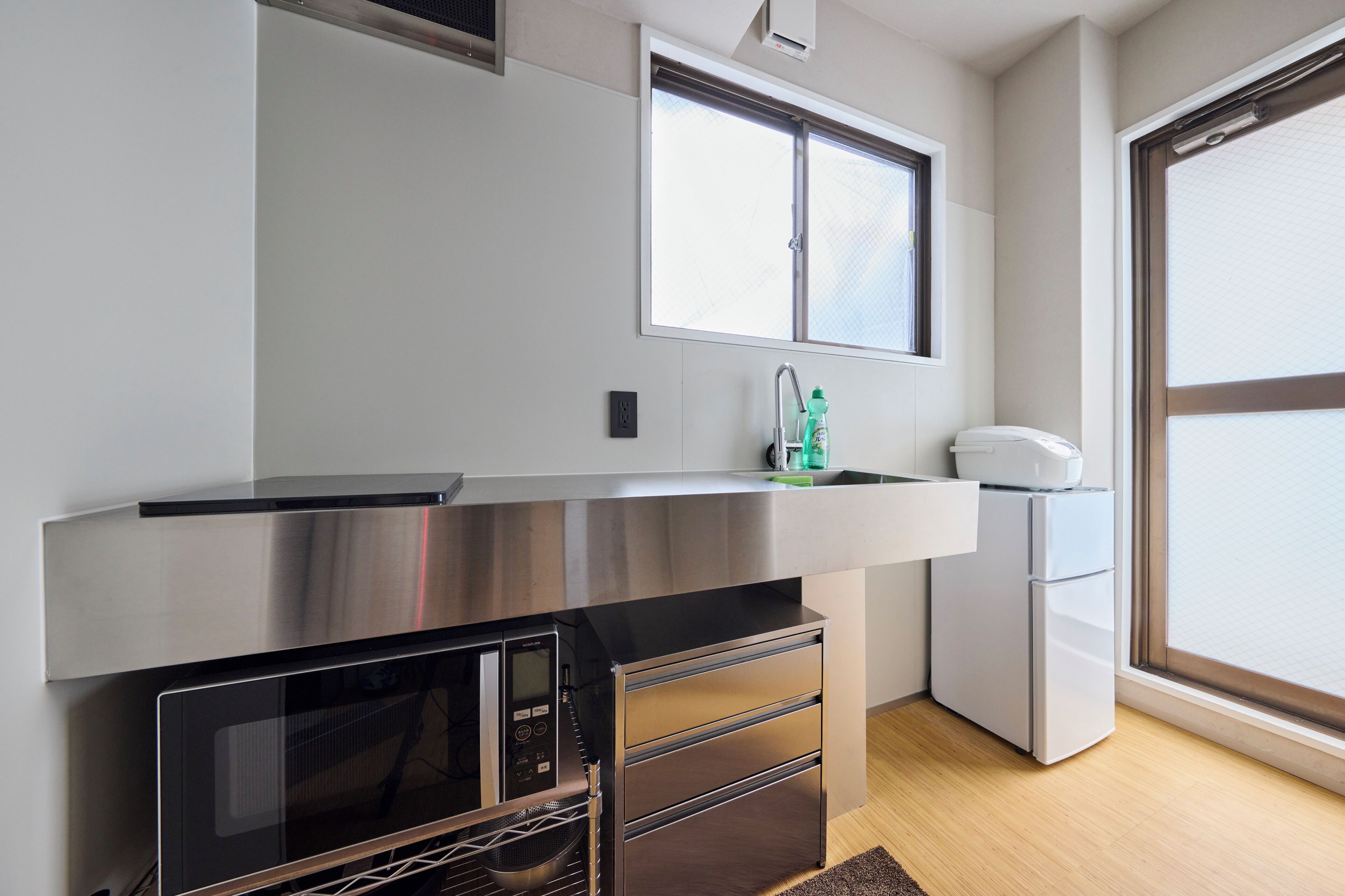 A modern kitchen with stainless steel appliances, a built-in oven, and a window above the sink.