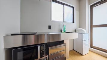 A modern kitchen with stainless steel appliances, a built-in oven, and a window above the sink.