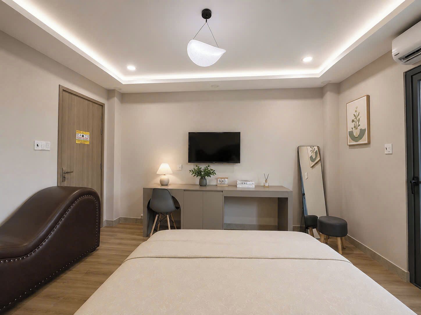 Een hotelkamer met een bed, een bureau met een lamp, een televisie en een stoel.