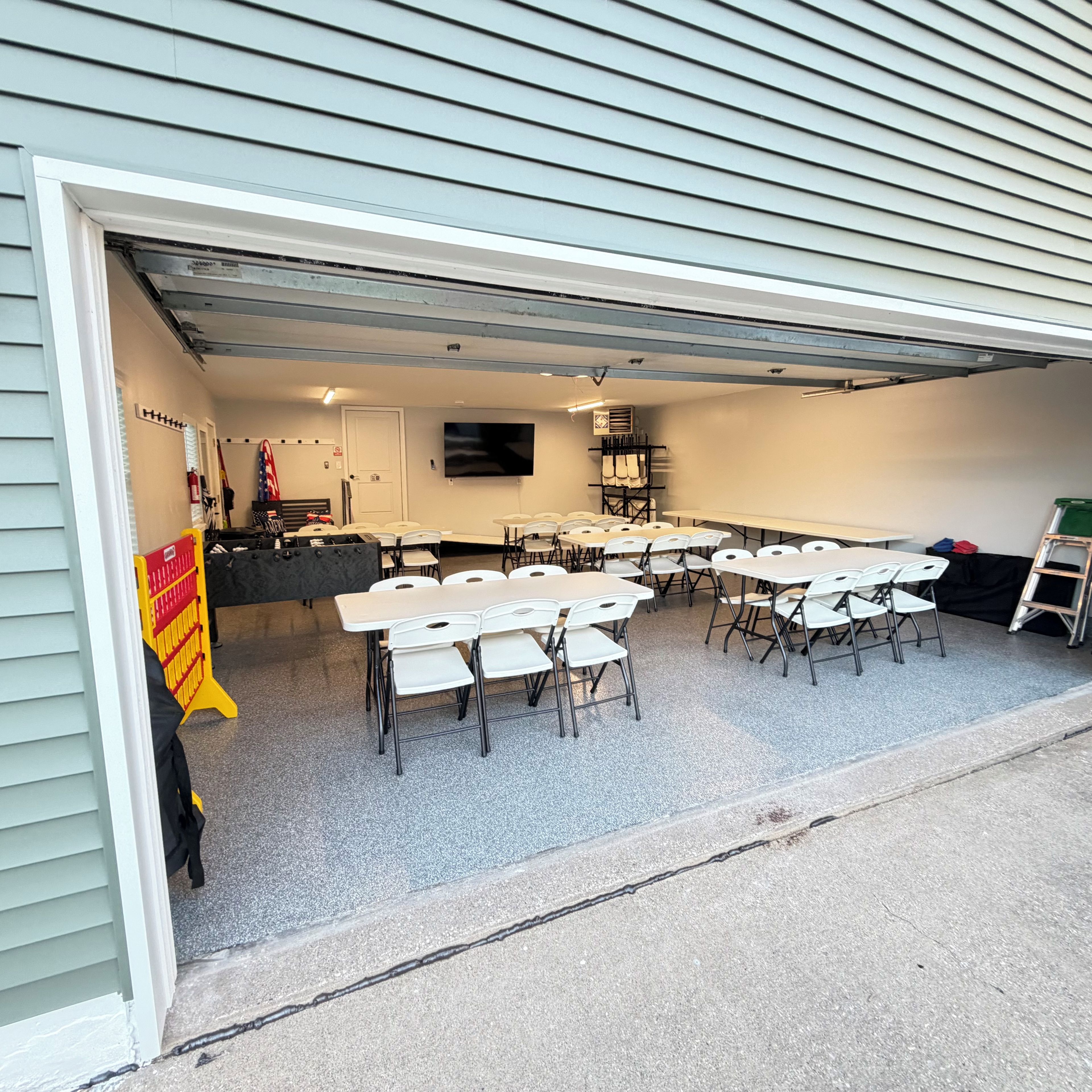 A covered outdoor area with tables and chairs arranged for dining or meetings.