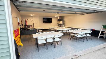 A covered outdoor area with tables and chairs arranged for dining or meetings.