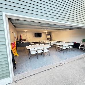 A covered outdoor area with tables and chairs arranged for dining or meetings.