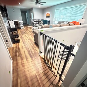 A spacious living area with a wooden floor, a dining table, and a sofa.