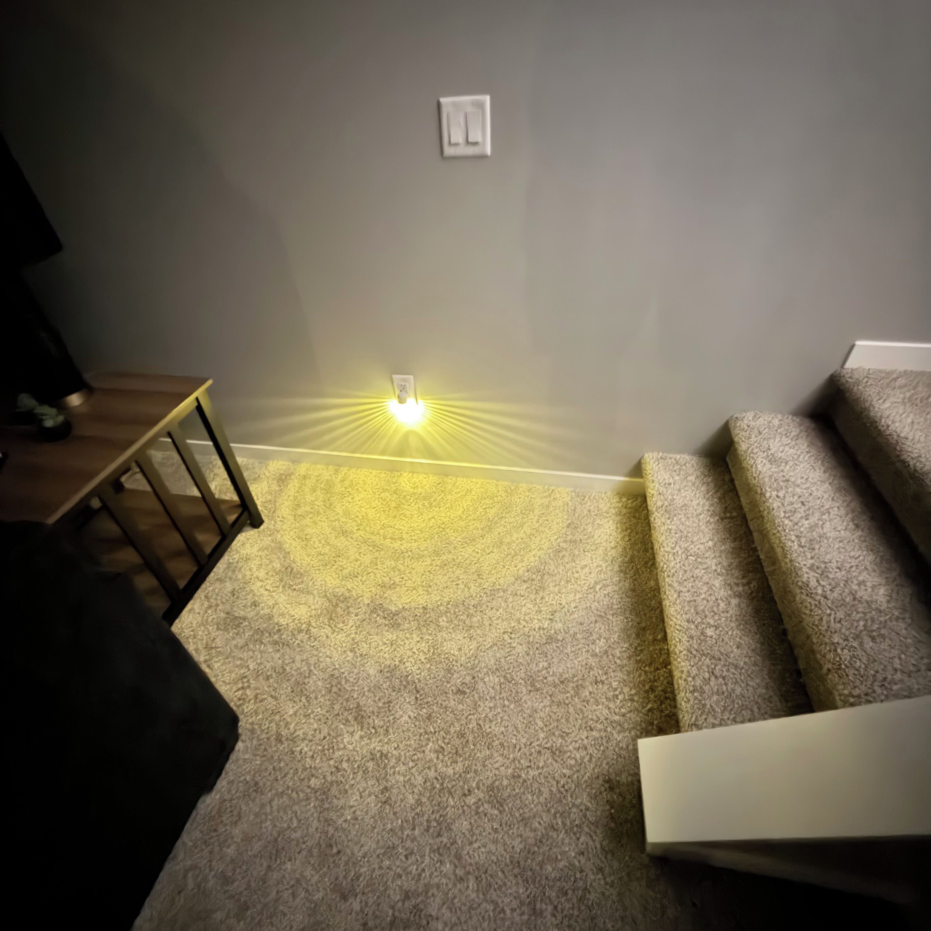 Una escalera empapelada con un aplique en la pared.