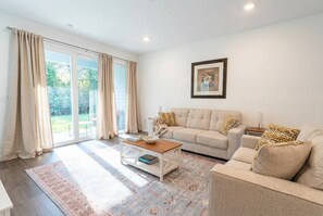 A living room with a sofa, coffee table, and a rug.