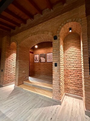 A room with brick walls, wooden beams, and a staircase leading to an upper level. - Casa Chimeneas: Perfect for families—just 10 minutes from downtown Avándaro! (Avandaro)