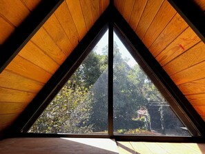 Un plafond triangulaire en bois avec une lucarne.