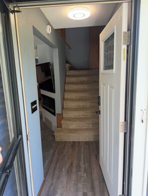 Una escalera que lleva a un rellano con una puerta a la derecha.