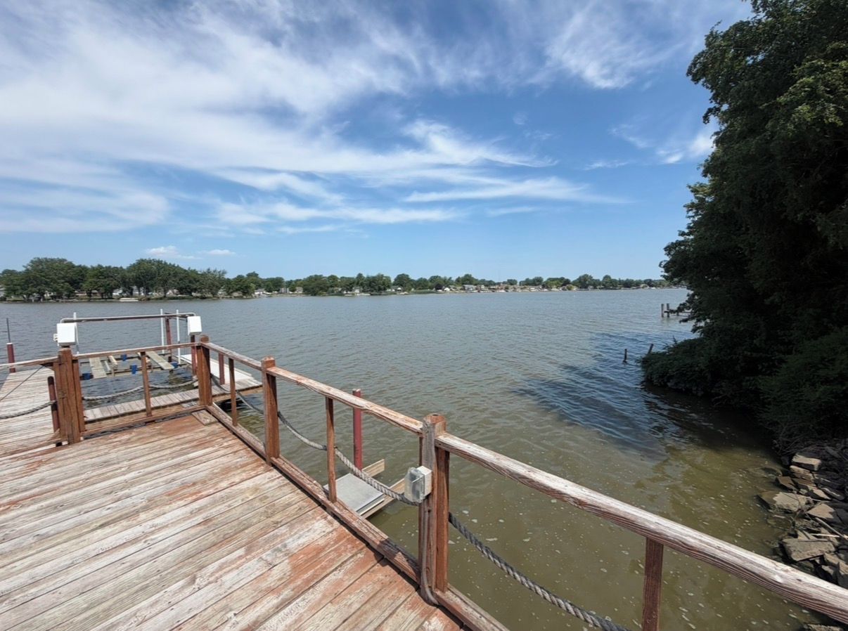 A wooden pier extending into a body of water with a clear sky above.