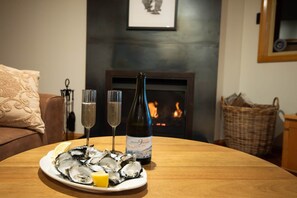 A dining table with a plate of oysters, two glasses of champagne, and a bottle of wine. - Breathtaking Views - 3 Bedroom House (Gordon)