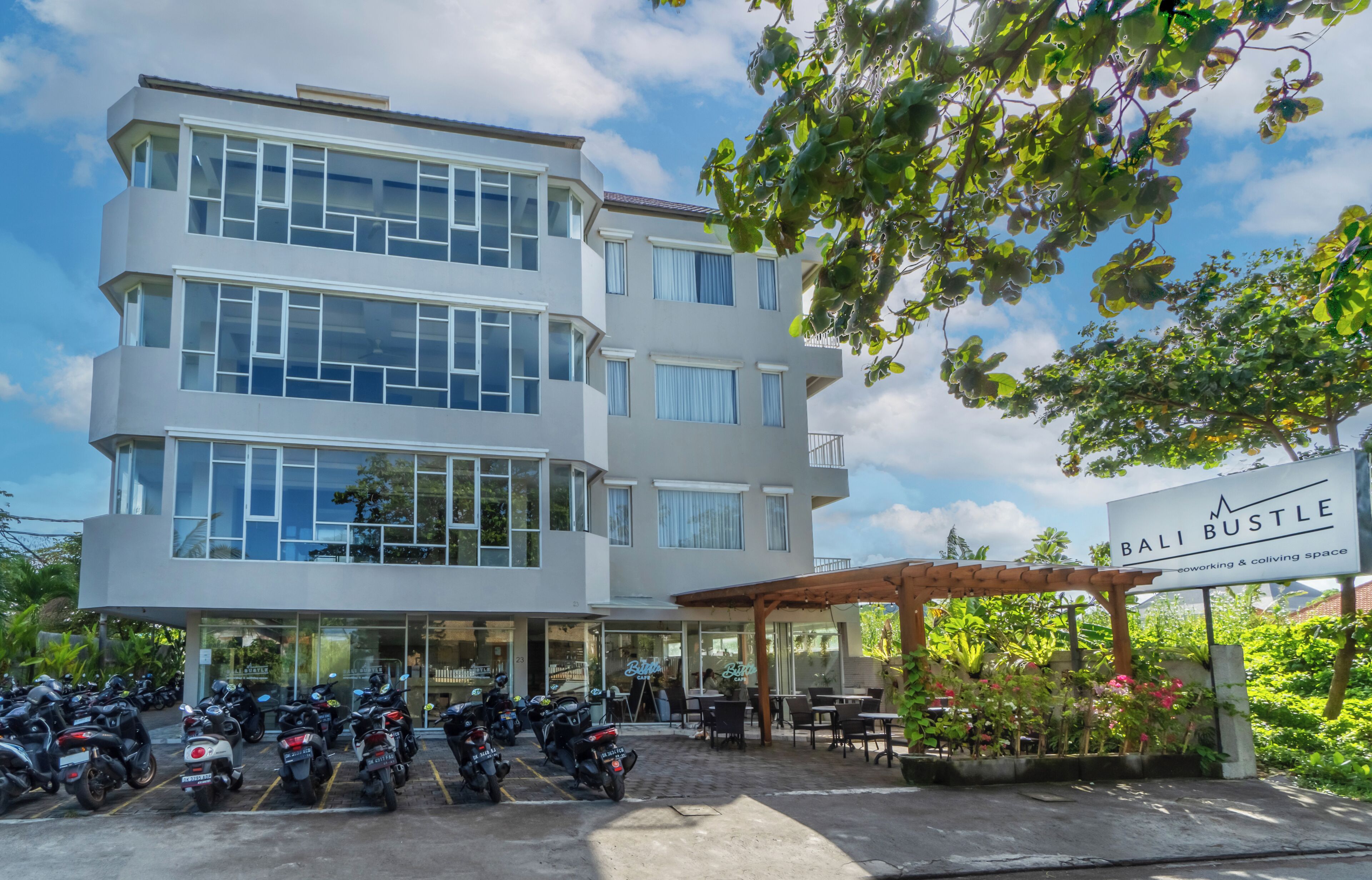 Um edifício de vários andares com um café chamado 'Bali Bustle' no andar térreo.