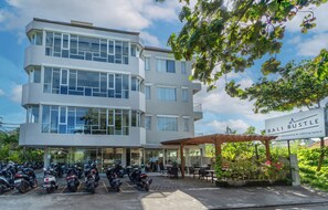 Ein mehrstöckiges Gebäude mit einem Café namens 'Bali Bustle' im Erdgeschoss.