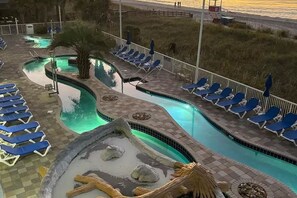 A pool area with lounge chairs and a small water feature.