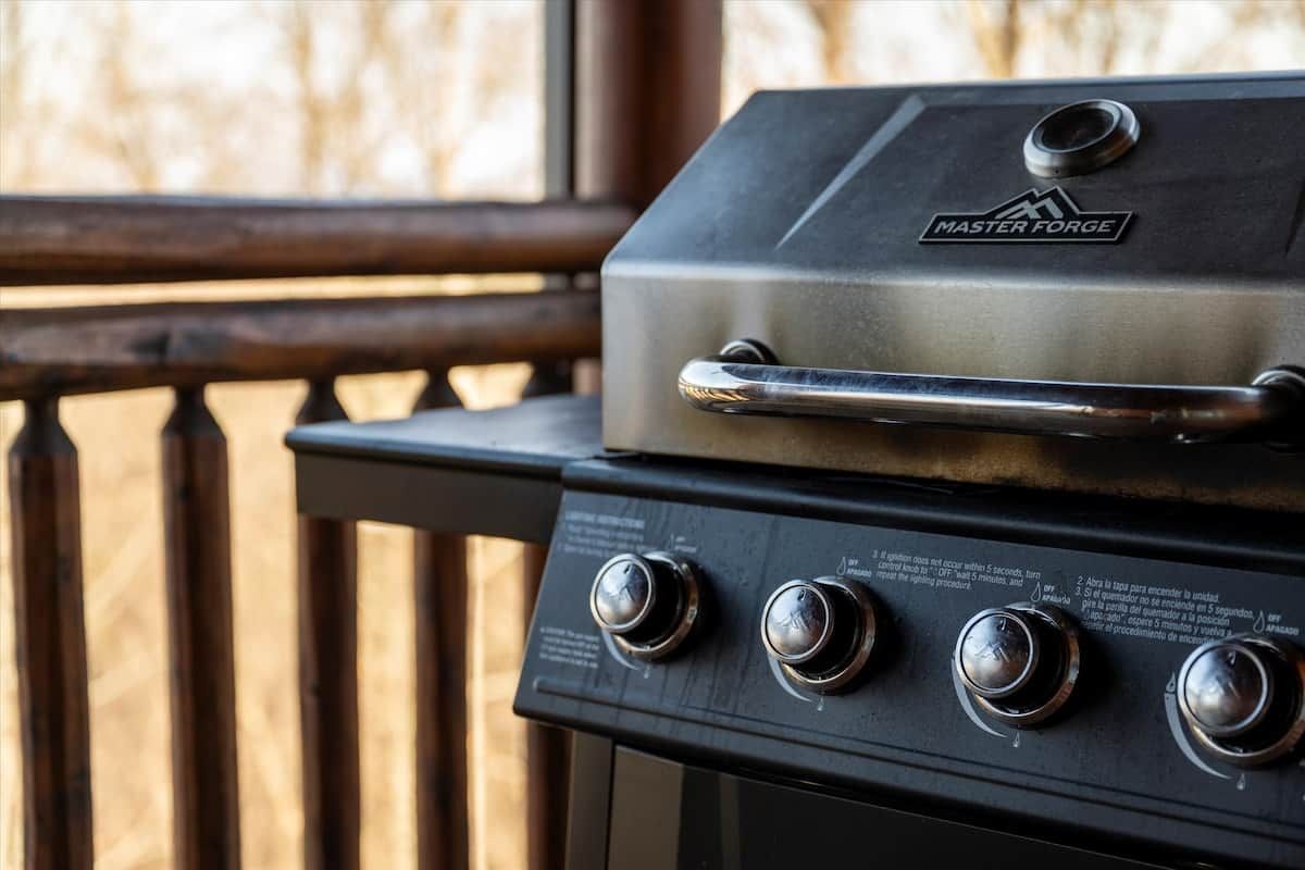 A Master Forge grill with a handle and four control knobs.