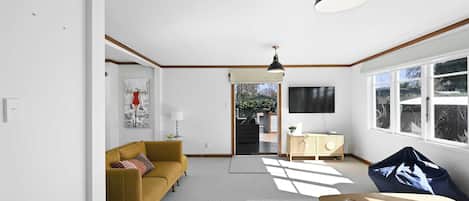 A modern living room with a sofa, a coffee table, and a TV.