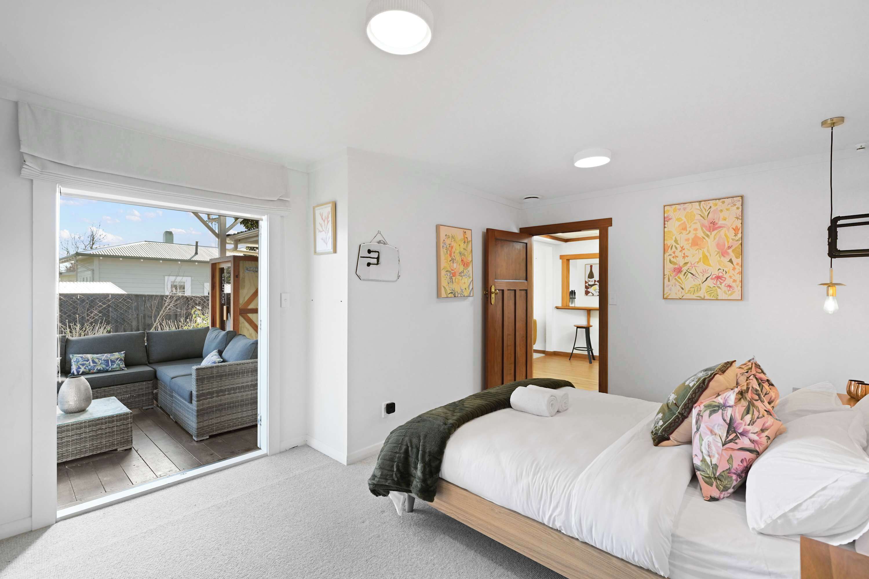 A bedroom with a bed, a sofa, and a view of the outside.
