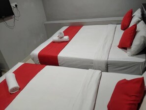 Two twin beds with red and white bedding, a flat-screen TV mounted on the wall, and a power outlet on the left. - Avatarr Hotel (Batu Caves)