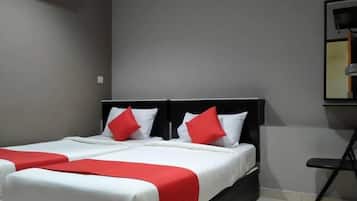 A hotel room with two beds, each with white bedding and red accents, a black headboard, and a wall-mounted air conditioner.