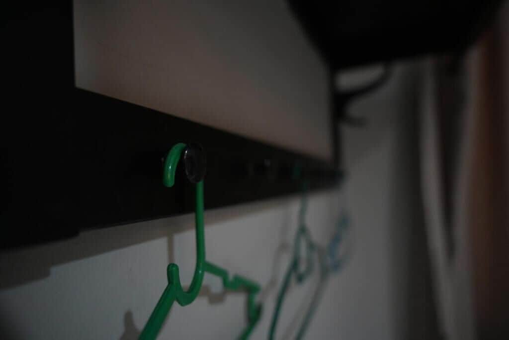 A close-up of a wall-mounted electrical panel with green cables connected to it.