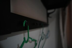 A close-up of a wall-mounted electrical panel with green cables connected to it. - Avatarr Hotel (Batu Caves)