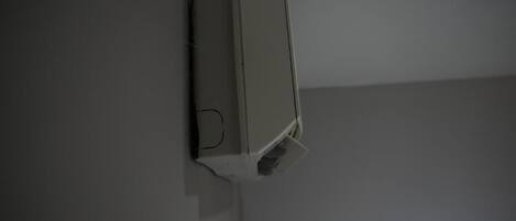 A white, rectangular object mounted on a wall, possibly a thermostat or control panel.