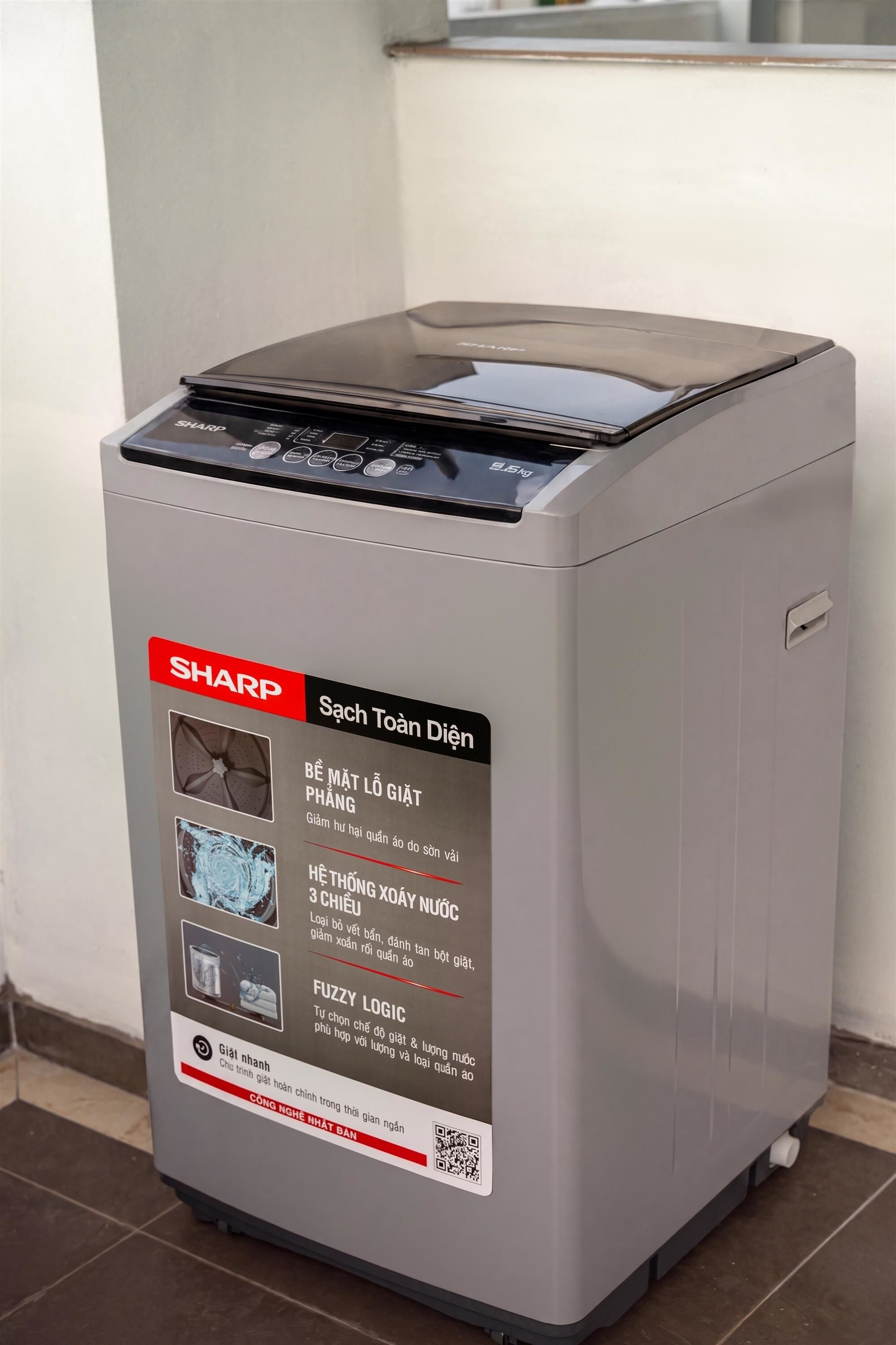 A SHARP washing machine with a control panel, a red label, and a QR code.