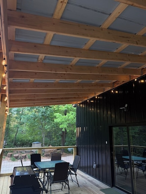 An outdoor deck with a table and chairs, surrounded by a wooden fence and trees. - Tall Pine Retreat — Cozy, Deep-Woods Getaway in tranquil Necedah (Necedah)