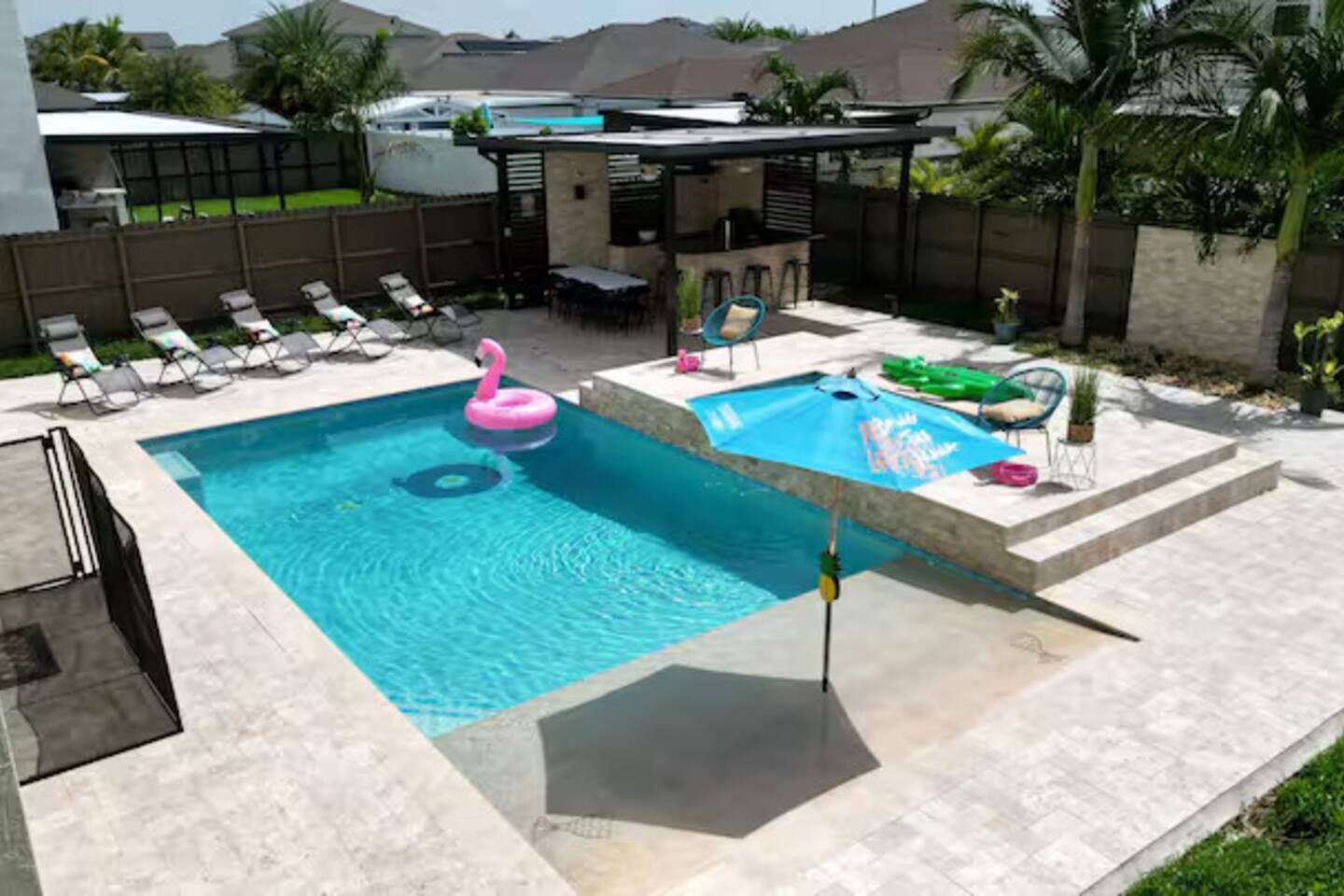 Una piscina con sillas de descanso y una pequeña terraza.
