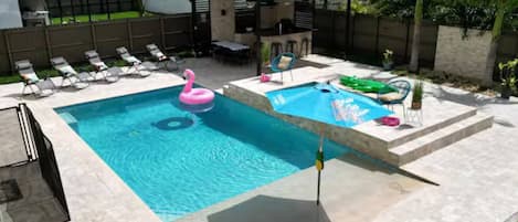 Una piscina con sillas de descanso y una pequeña terraza.