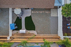 A rooftop patio with a seating area, a barbecue grill, and a small garden.