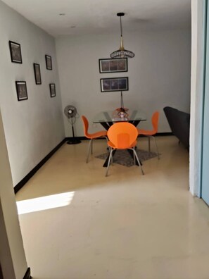 A dining area with a table and chairs, a ceiling fan, and framed pictures on the wall. - Casa FRIDA25 (Chelem)