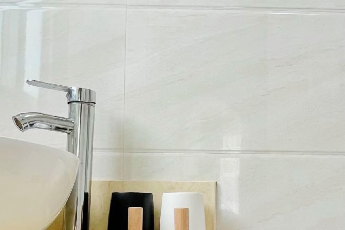 A bathroom with a chrome faucet and a white sink.