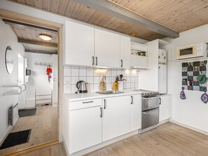 A modern kitchen with white cabinetry, a built-in oven, and a microwave.