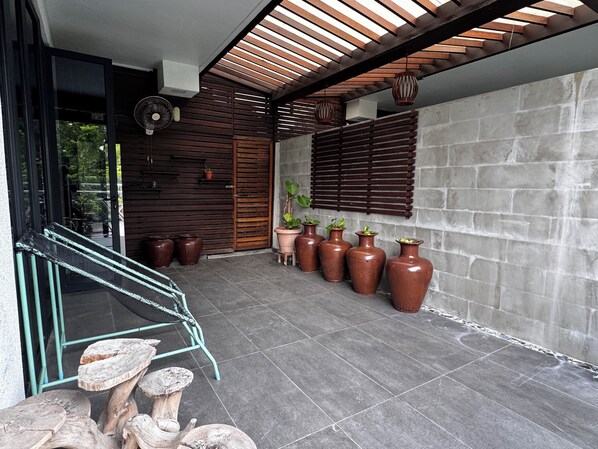 A modern interior with a staircase, potted plants, and a concrete wall.