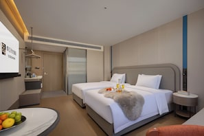 A hotel room with a bed, bedside table, and a desk with a chair.