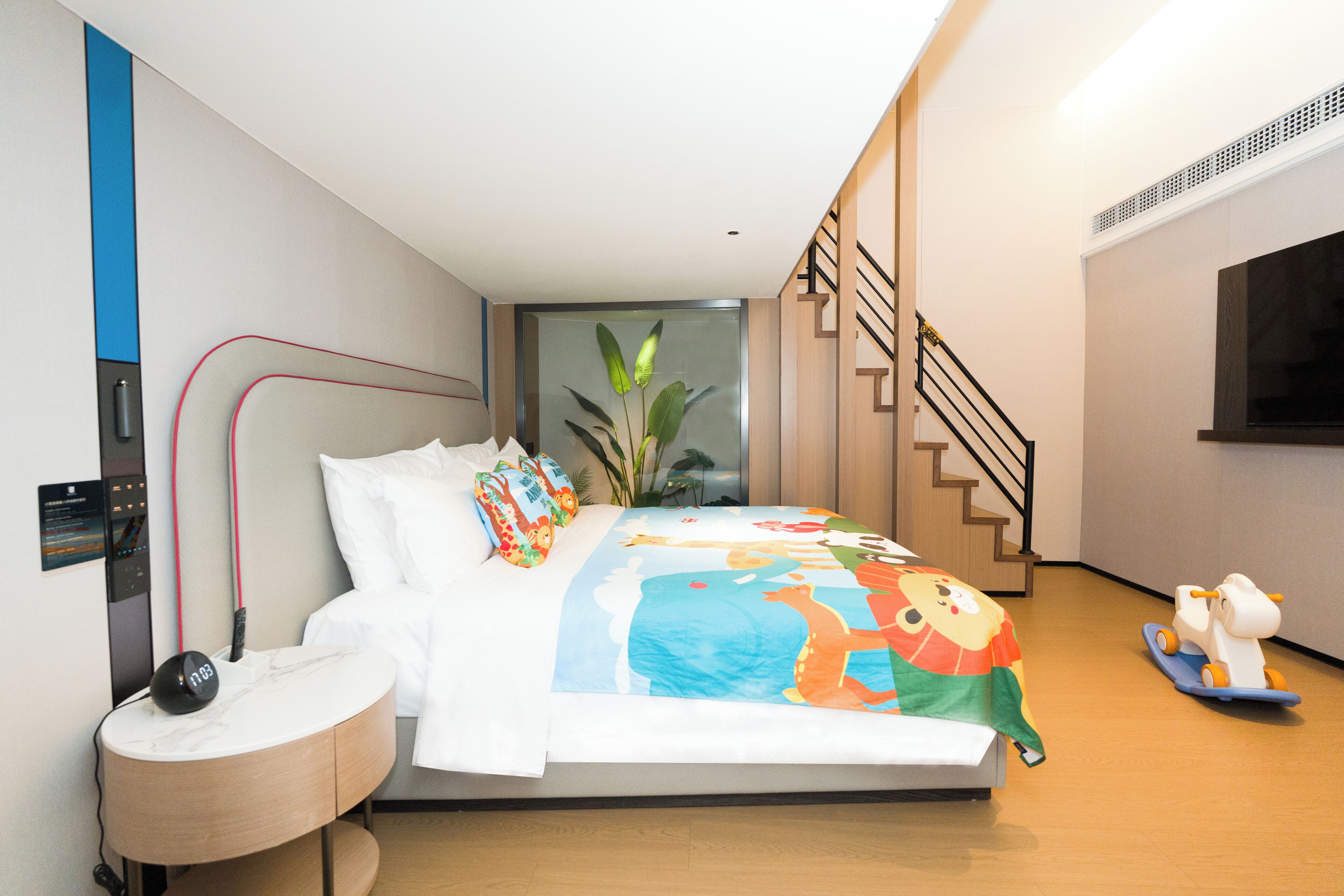 Un dormitorio moderno con cama, mesita de noche y un pequeño escritorio.