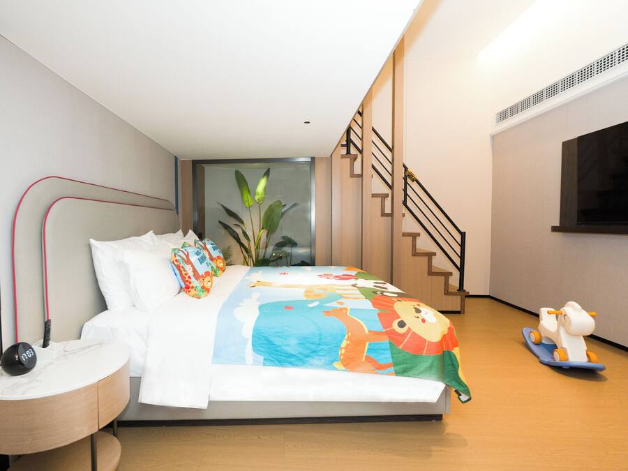 Un dormitorio moderno con cama, mesita de noche y un pequeño escritorio.