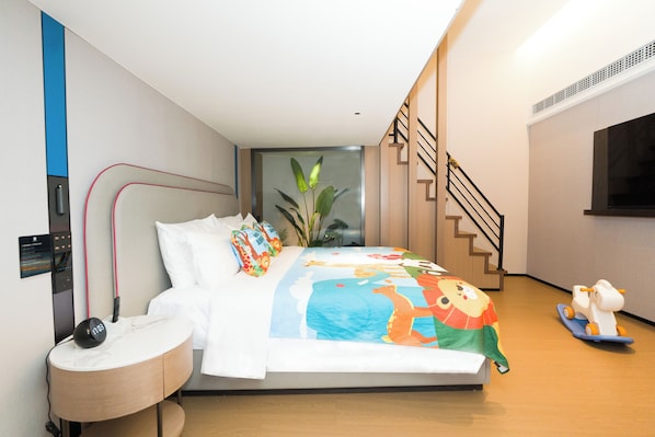 A modern bedroom with a bed, bedside table, and a small desk.